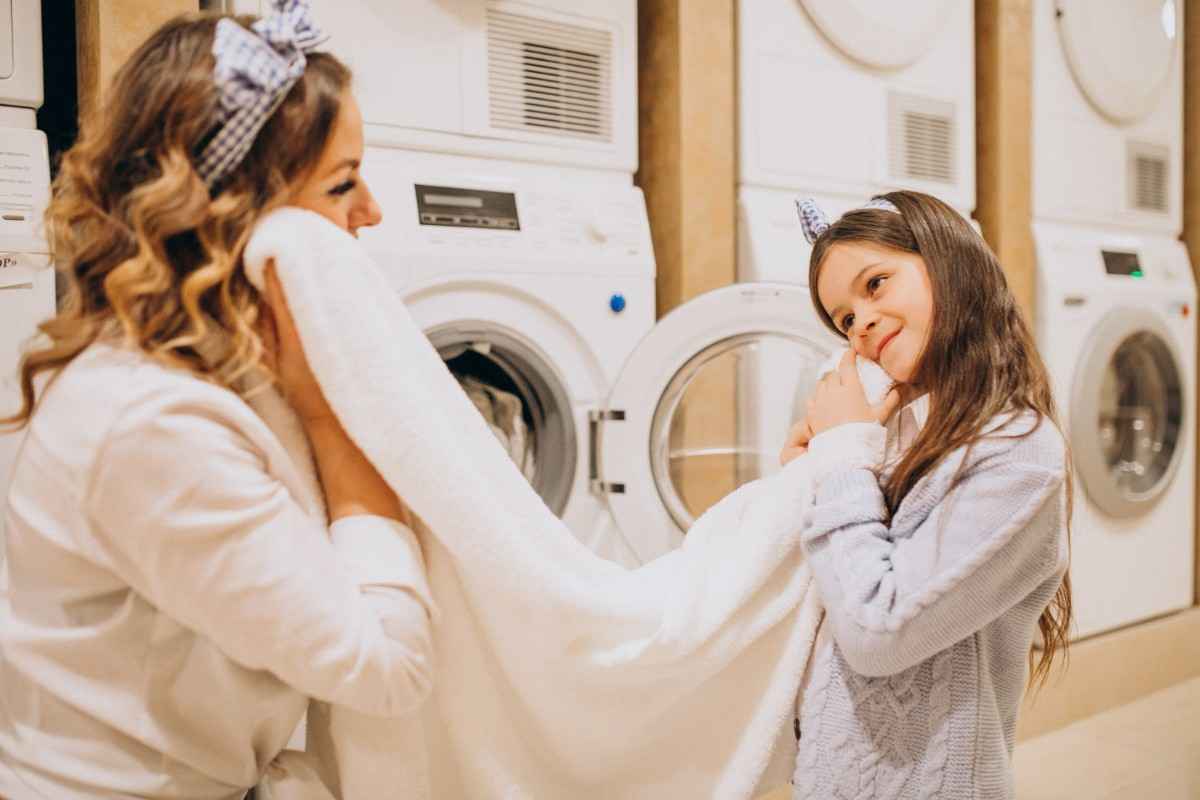A mother with daughter doing laundry self service laundrette