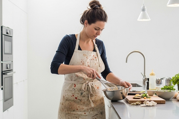 Chef Uniform Wearing Stained Apron While Cooking, Illustrating the Need for Uniform Washing and Preservation