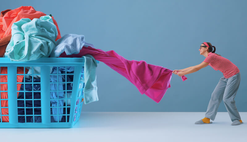 A smiling customer inspecting freshly laundered white shirts in protective plastic covers, celebrating the high standards of National Dry Cleaning Day with ByNext.