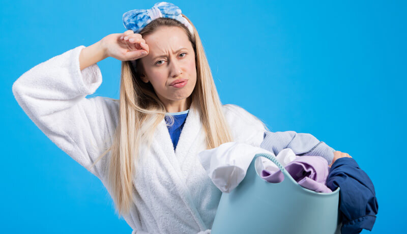 Close-up of a professional technician gently hand-washing a delicate red garment in a specialized basin, demonstrating ByNext's commitment to damage-free cleaning for high-risk items.